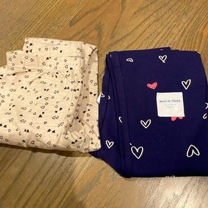 Two little girls old navy heart print leggings. One still with tags